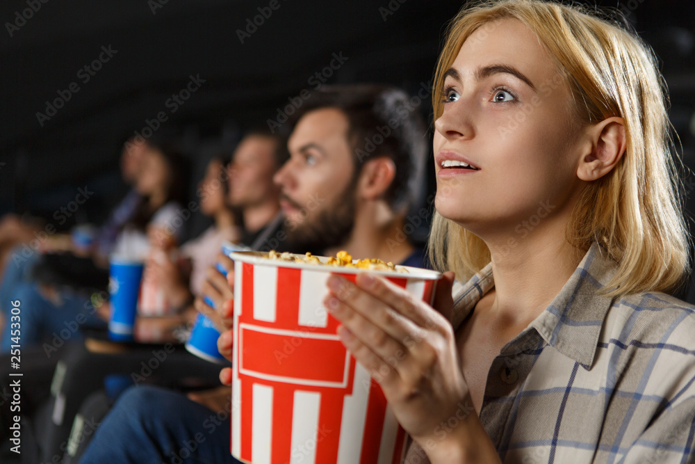 Side View Of Shocked Beautiful Blonde Woman Watching Excited Horror In Cinema Hall Girl In