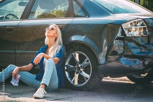 girl sits on the road, near the broken car holding money in his hand, thinking whether there is enough for repair.