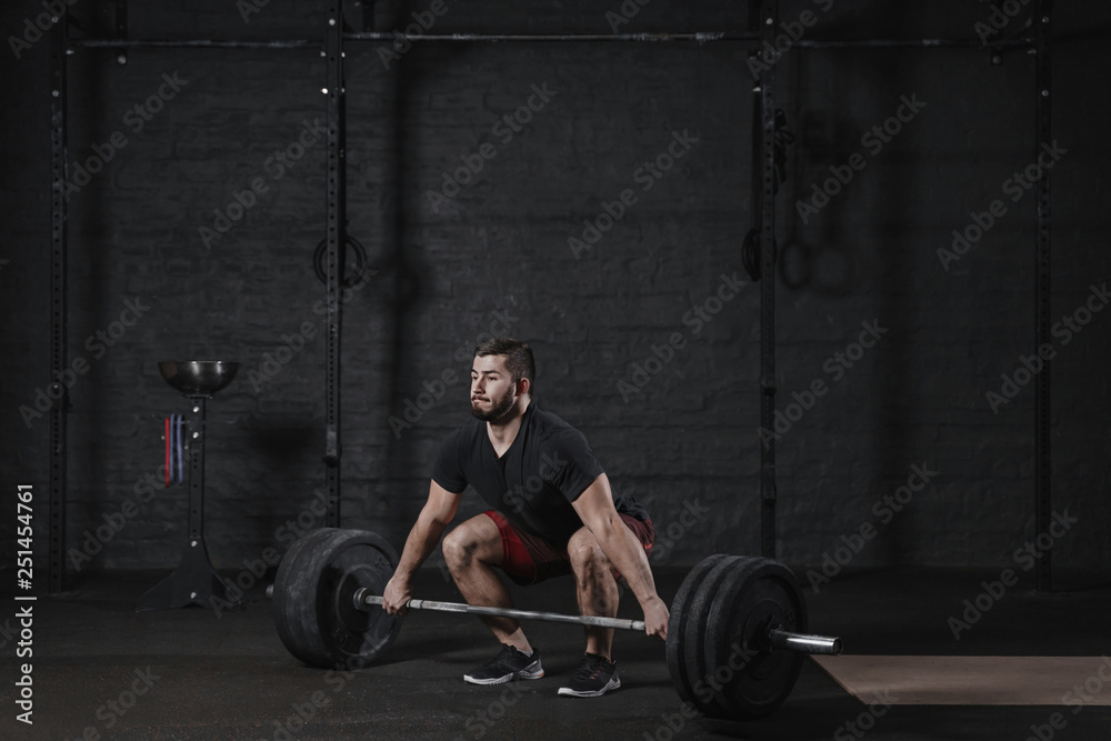 Young crossfit athlete doing deadlift exercise with heavy barbell at the gym. Man practicing functional training powerlifting workout Young crossfit athlete doing deadlift exercise with heavy barbell at the gym. Man practicing functional training powerlifting workout