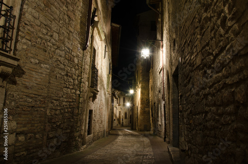Medieval old street in Assisi by night, Umbria, central Italy