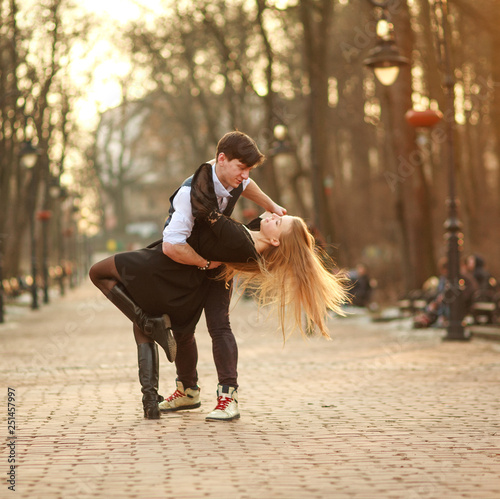 Elegant young couple in love in classic style passionately dancing in city park