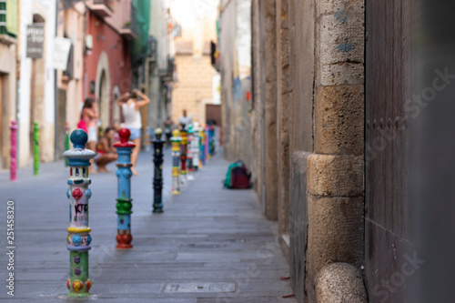 Bolardos pintados y dibujados de diferentes colores en una calle de Tarragona. España