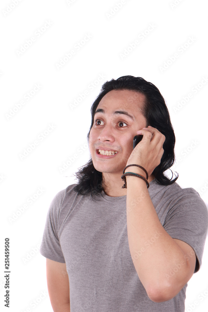 Young Man Talking on Phone, Shocked Worried Expression Young Man Talking on Phone, Shocked Worried Expression