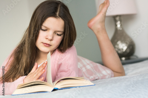 Urgent schoolgirl is reading a book