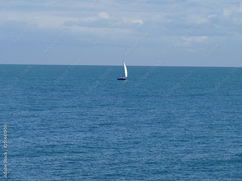 Orizzonte marino con barca a vela in solitudine