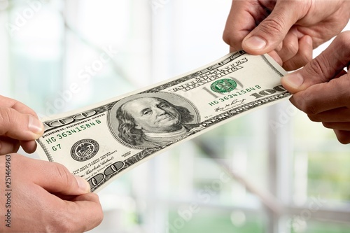 Hands holding one hundred dollars banknote over background