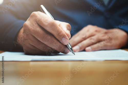 businessman writing on paper report in office photo