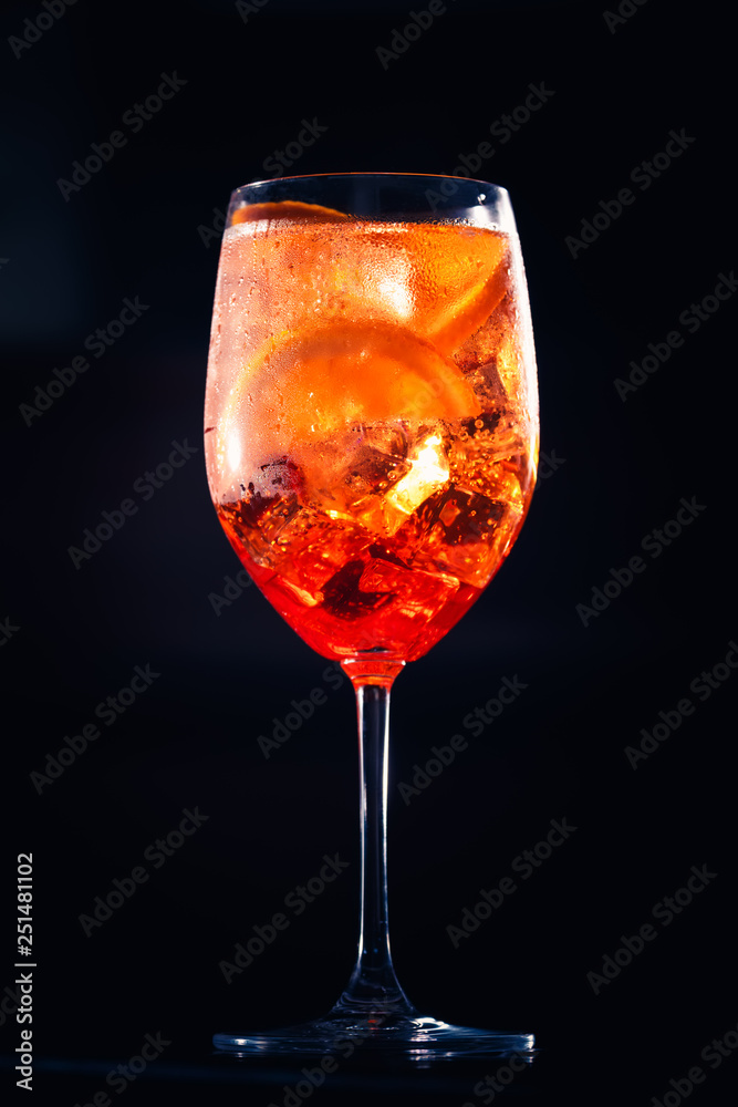 Stylish alcoholic aperol spritz cocktail with orange slice on black background. Stylish alcoholic aperol spritz cocktail with orange slice on black background.