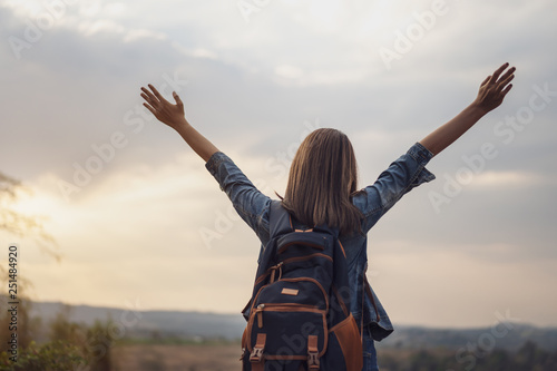 traveler woman with backpack with arms raised