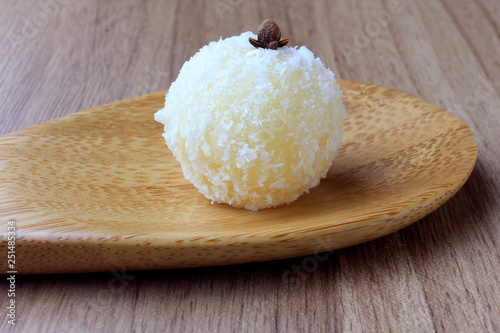 coconut kiss (beijinho de coco) - typical sweet Brazilian cuisine isolated on wooden background photo