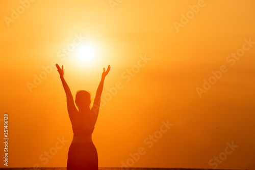 Happy successful fitness woman raising arms to the sky at sunset. Success, celebrating goals and achievement. Healthy Active Lifestyle