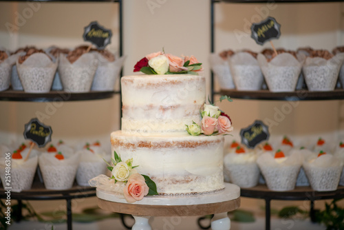 White three tier naked wedding cake with pink, red and white roses