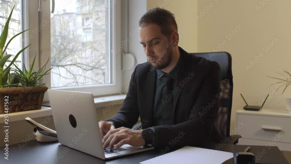 businessman working on laptop in office taking notes businessman working on laptop in office taking notes