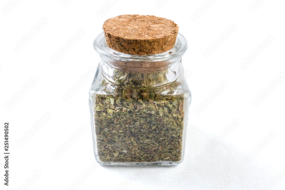 marjoram herb in a glass jar isolated on white background marjoram herb in a glass jar isolated on white background