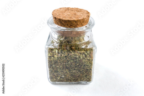 marjoram herb in a glass jar isolated on white background