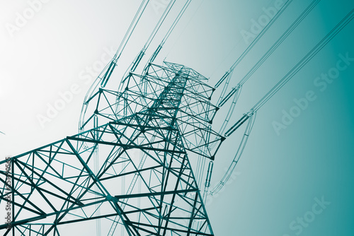 Abstract pattern from bottom view of high voltage pole power transmission tower with clear sky sunny day background in monochrome tone. Green energy, environmental conservation concept.