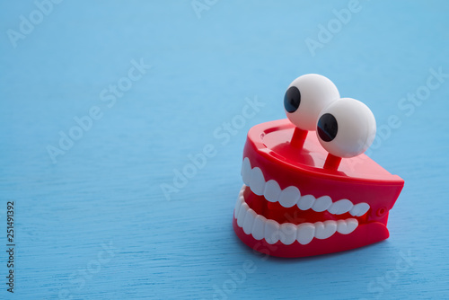 Chattering teeth toy wind up moving on blue background. Funny, comedy, relax time concept