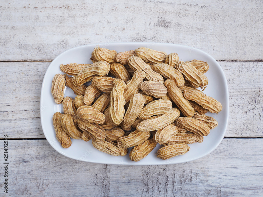 boiled peanuts on plate over wooden table. boiled peanuts on plate over wooden table.