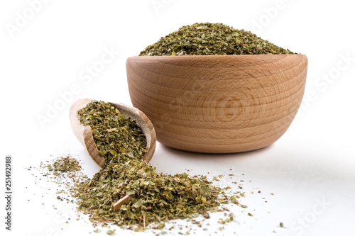 marjoram herb in wooden bowl and scoop isolated on white background