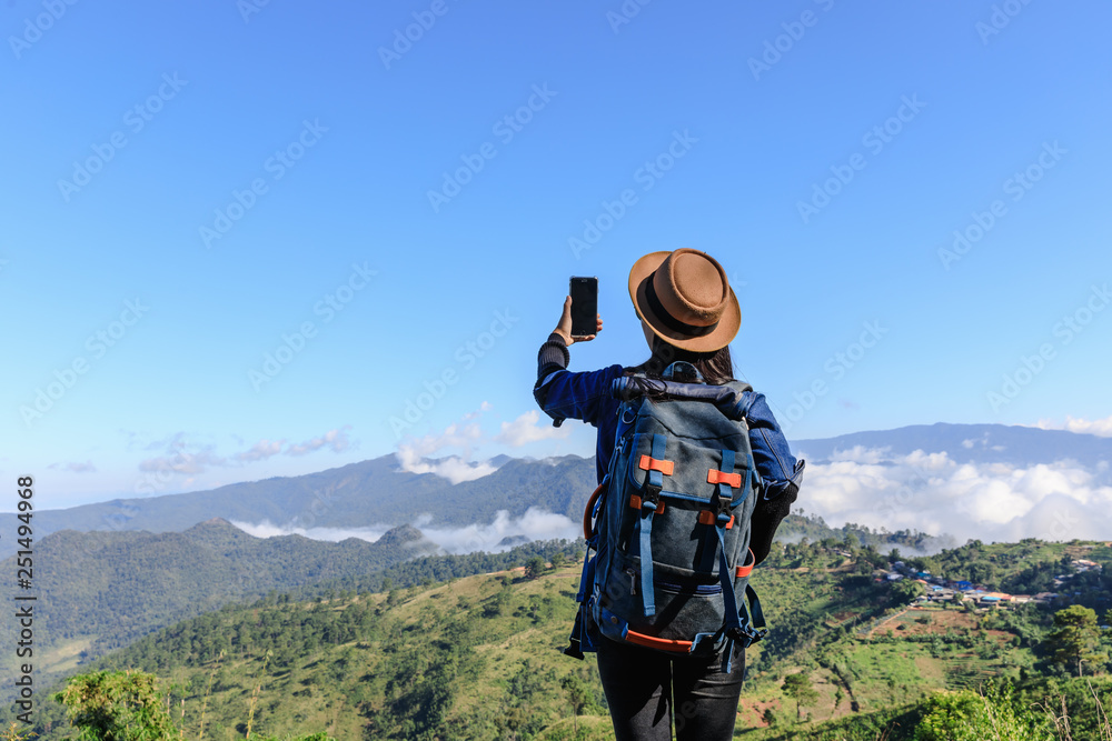 young asian women backpack tourists checking signal 4g gps and map on smartphone on the mountain and mountain fog clear sky background