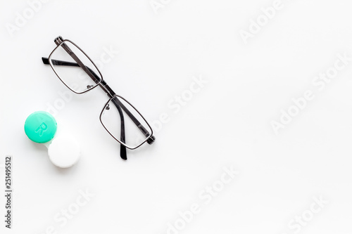 Eyes care. Glasses with transparent lenses and contact lenses on white background top view space for text