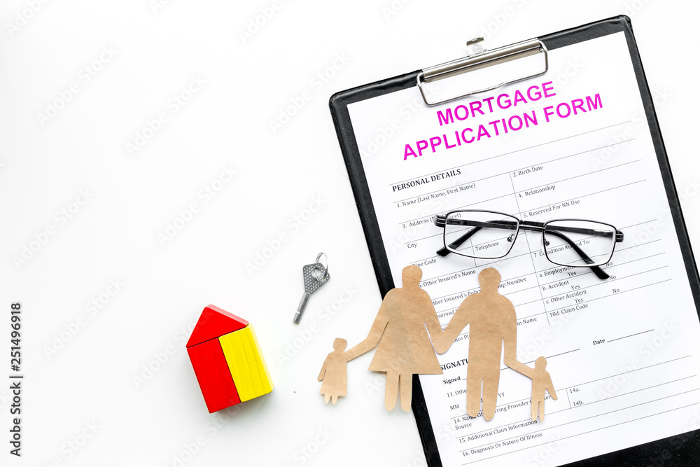 Mortgage concept. Mortgage application form near key and house made of constructor, family cutout on white background top view copy space Mortgage concept. Mortgage application form near key and house made of constructor, family cutout on white background top view copy space