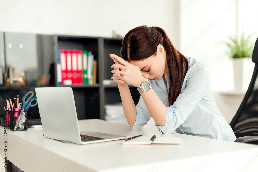 Business concept - concentrated young business woman is thinking while sitting at her desk with the laptop in the office Business concept - concentrated young business woman is thinking while sitting at her desk with the laptop in the office