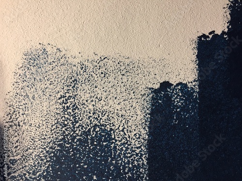 Blue paint patterns in freshly painted white wall with single brush strokes visible