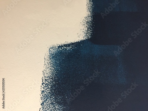 Blue paint patterns in freshly painted white wall with single brush strokes visible