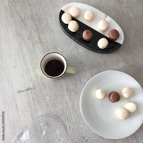 Dark and white cholcolate macarons on wooden table photo