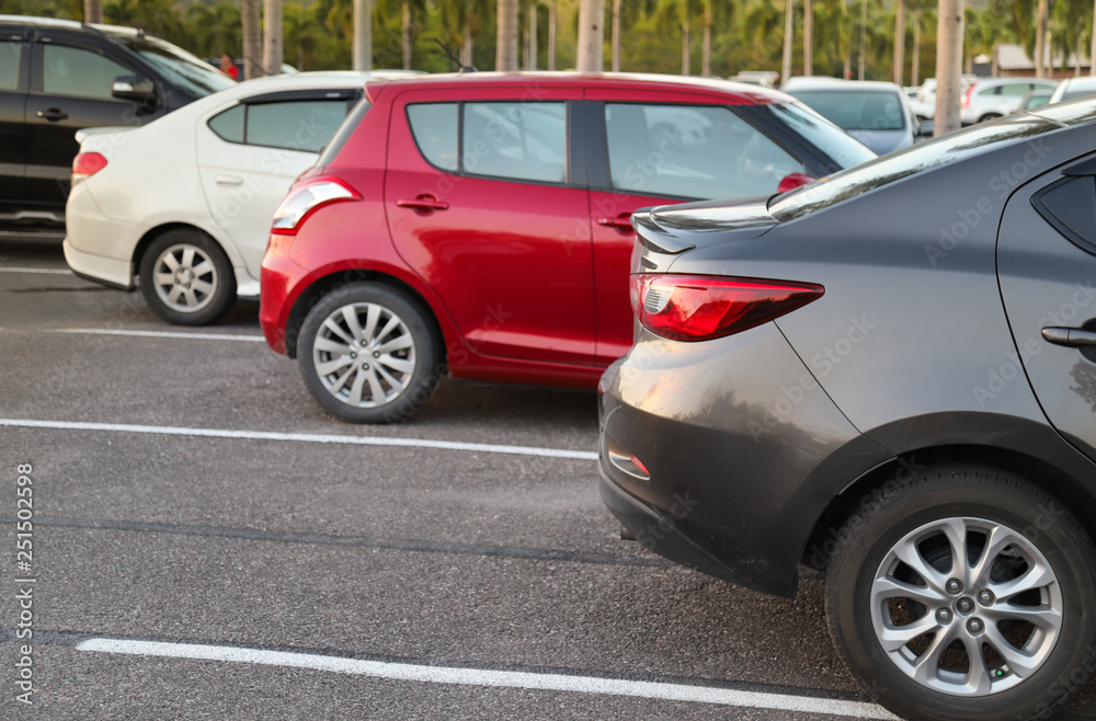 Closeup of back or rear side of brown car and other cars parking in parking area with natural background in twilight evening. 