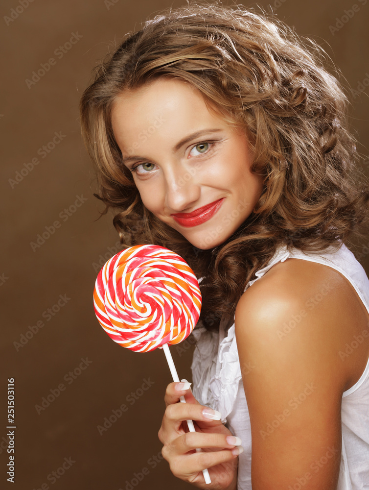  Beauty curly girl portrait holding colorful lollipop.
