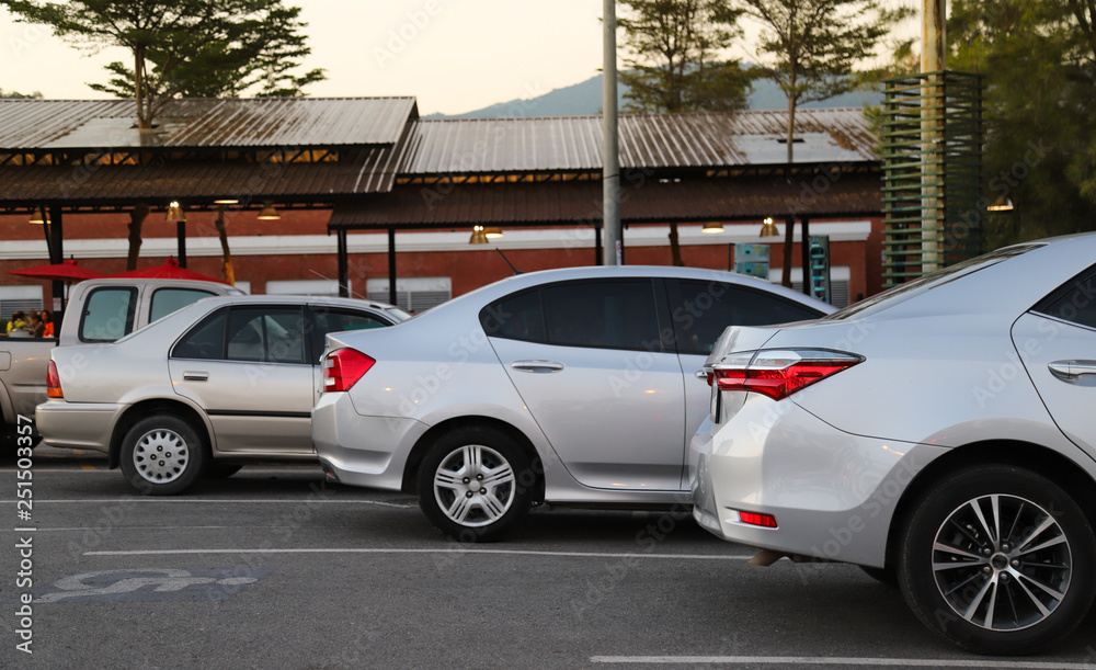 Closeup of back or rear side of bronze car and other cars parking in parking area with natural background in twilight evening. Closeup of back or rear side of bronze car and other cars parking in parking area with natural background in twilight evening.