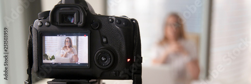 Businesswoman sitting at modern office talking on camera recording presentation photo