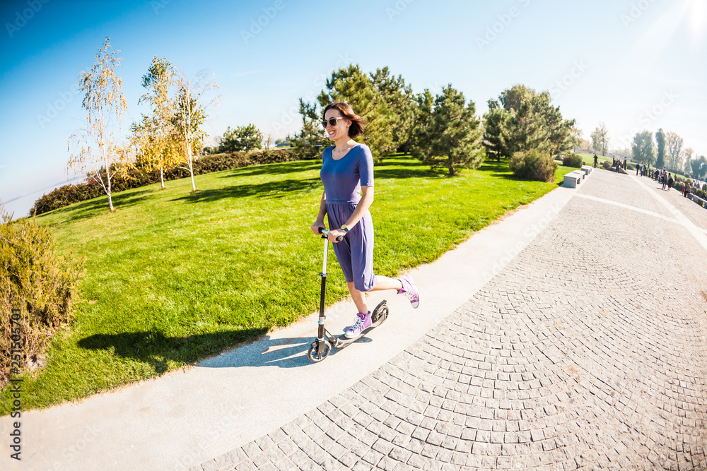 The girl rides a scooter in the park.
