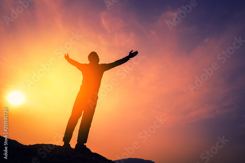 Copy space of man rise hand up on top of mountain and sunset sky abstract background.