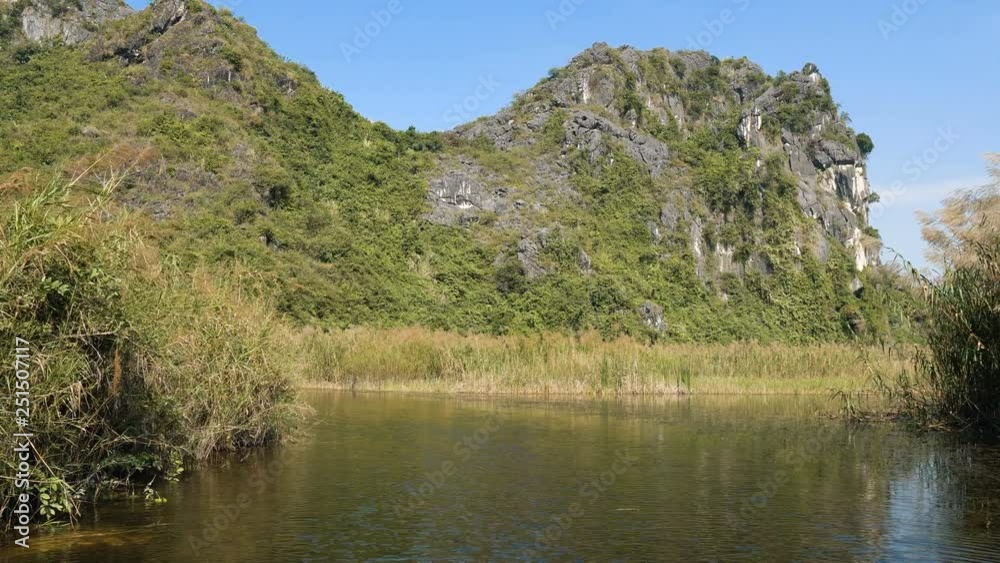 Panorama view of beautiful karst scenery, wetlands seen from the boat at Van Long Nature Reserve, Vietnam. Tourists traveling in small boat in tranquil landscape. Panorama view of beautiful karst scenery, wetlands seen from the boat at Van Long Nature Reserve, Vietnam. Tourists traveling in small boat in tranquil landscape.