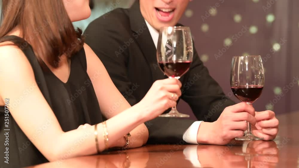 バーでワインを飲みながら談笑をするカップル バーでワインを飲みながら談笑をするカップル