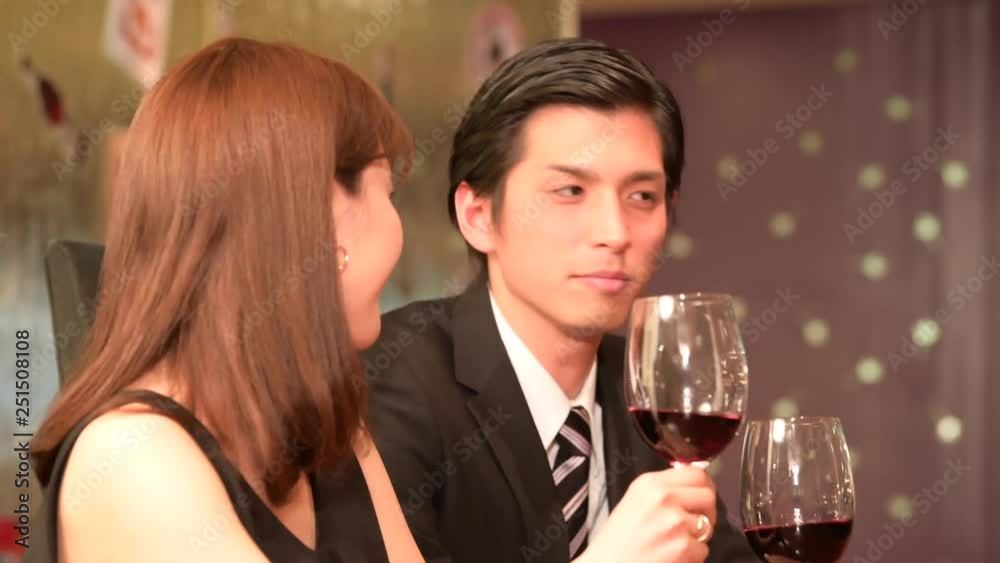 レストランでワインを飲みながら会話をするカップル レストランでワインを飲みながら会話をするカップル
