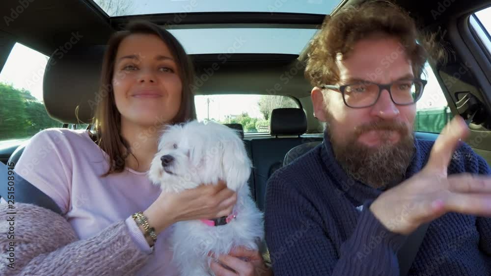 Happy family driving car with puppy dog having a good time Happy family driving car with puppy dog having a good time