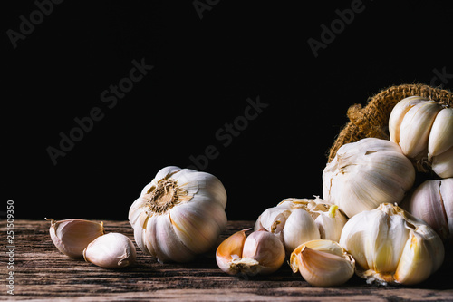 Closeup garlic on wooden texture on for cooking on dark background.