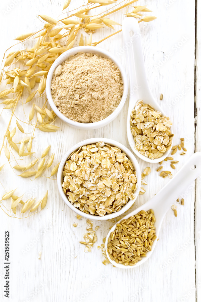 Oat flakes with flour and grain on board top Oat flakes with flour and grain on board top