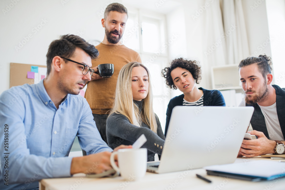 Group of young businesspeople with laptop working together in a modern office. Group of young businesspeople with laptop working together in a modern office.