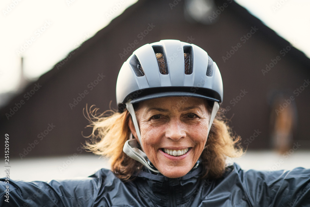A front view portrait of cheerful active senior woman standing outdoors. A front view portrait of cheerful active senior woman standing outdoors.