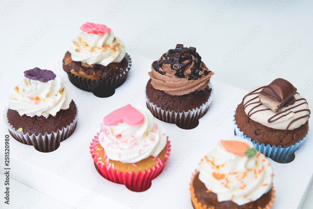 decorated cupcakes with strawberry, vanilla, caramel and chocolate frosting