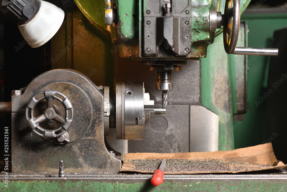 Spindle chuck and installed metal part in pocessing on high precision Cnc industrial lathe turning machine. CNC machine cuts off excess edges on metal part