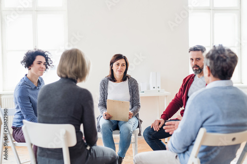 Men and women sitting in a circle during group therapy  talking.