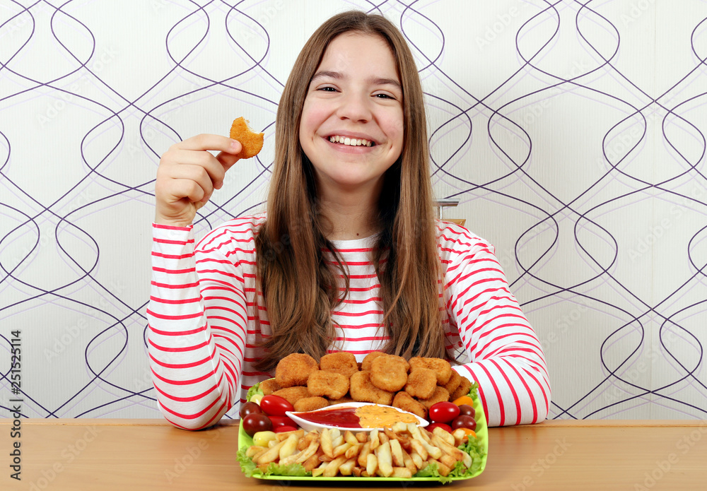 Φωτογραφία Happy teenage girl with tasty chicken nuggets and french fries
