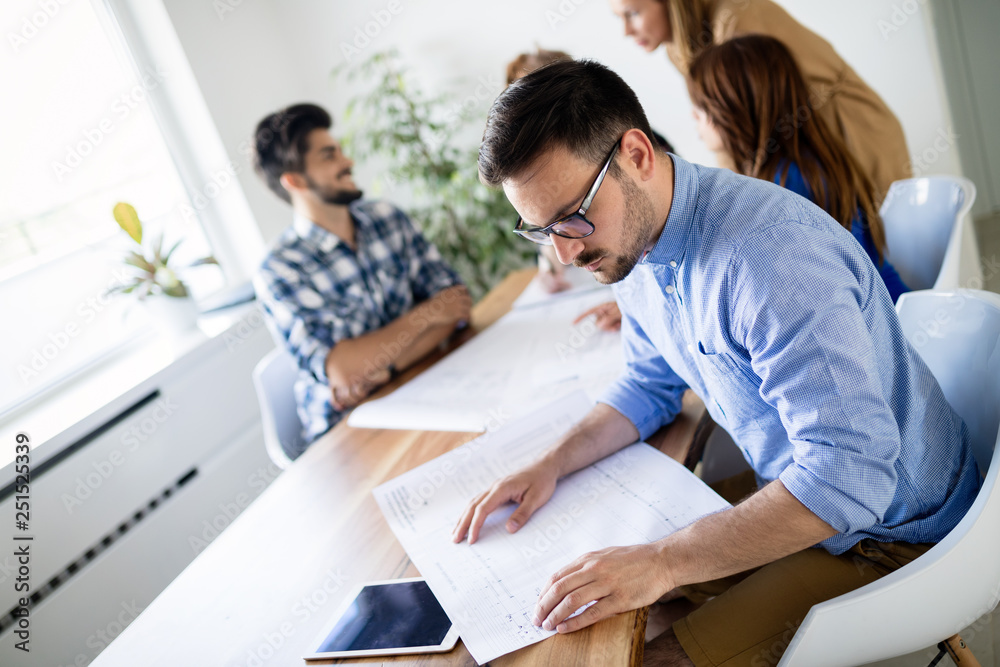 Obraz premium Creative young business people and architects working in office