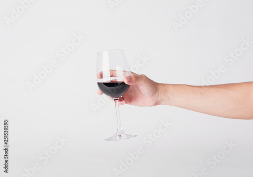 hand holding red wine glass on a white background.
